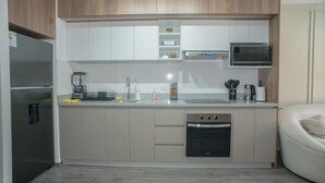 Eine moderne Küche mit einbauendem Backofen, Mikrowelle und Kaffeemaschine auf der Arbeitsfläche.