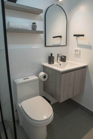 A modern bathroom with a toilet, sink, and mirror. - Modern studio near Qorikancha (Cusco)