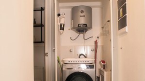 Ein Waschraum mit Waschmaschine, Trockner und Warmwasserbereiter.