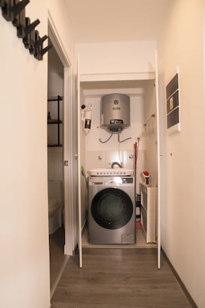 A laundry room with a washing machine, a dryer, and a water heater. - Spacious family apartment near the center (Cusco)