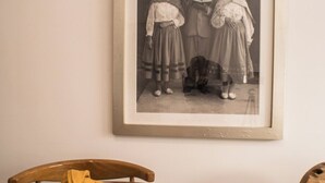 Ein Esstisch mit einem schwarzen und weißen Foto im Rahmen darüber.