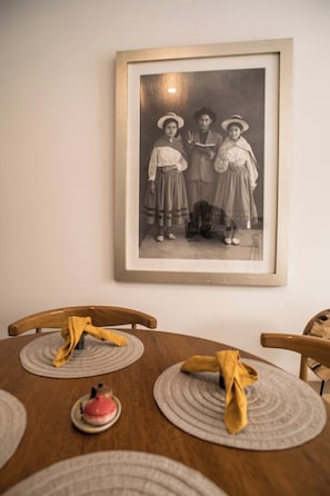 A dining table with a framed black and white photograph above it. - Spacious family apartment near the center (Cusco)
