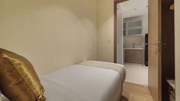 Un dormitorio con cama, una puerta que da a un baño y un armario de madera.