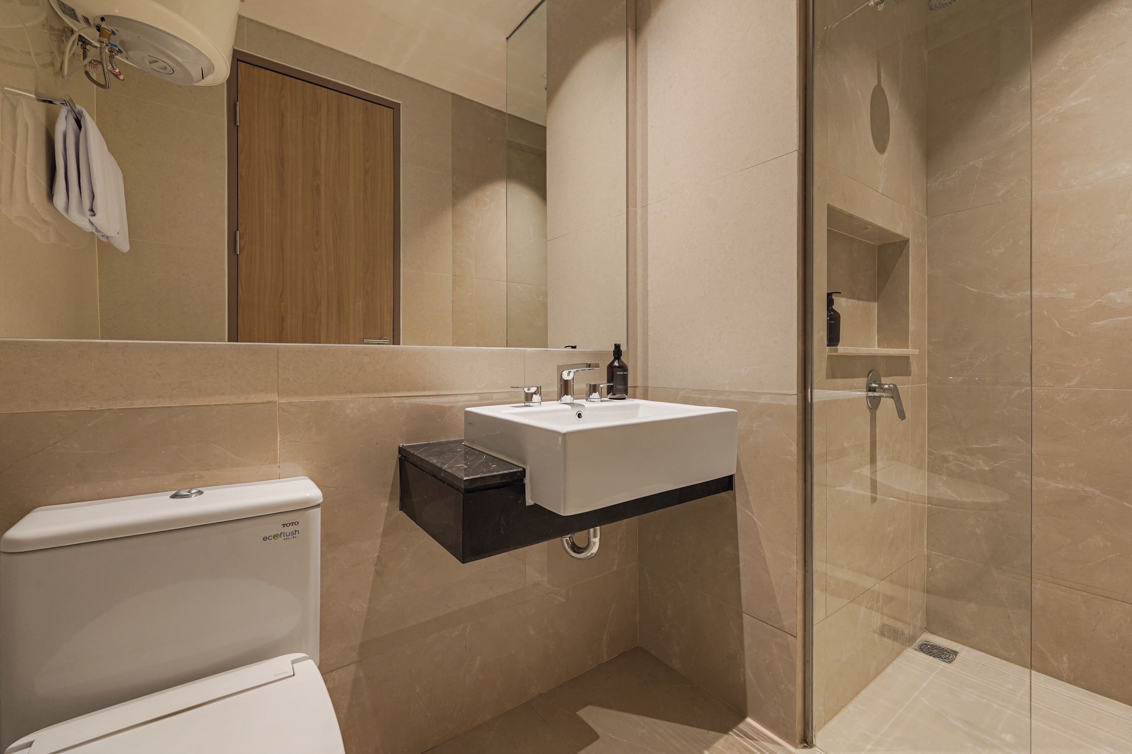 A modern bathroom with a toilet, sink, and shower.