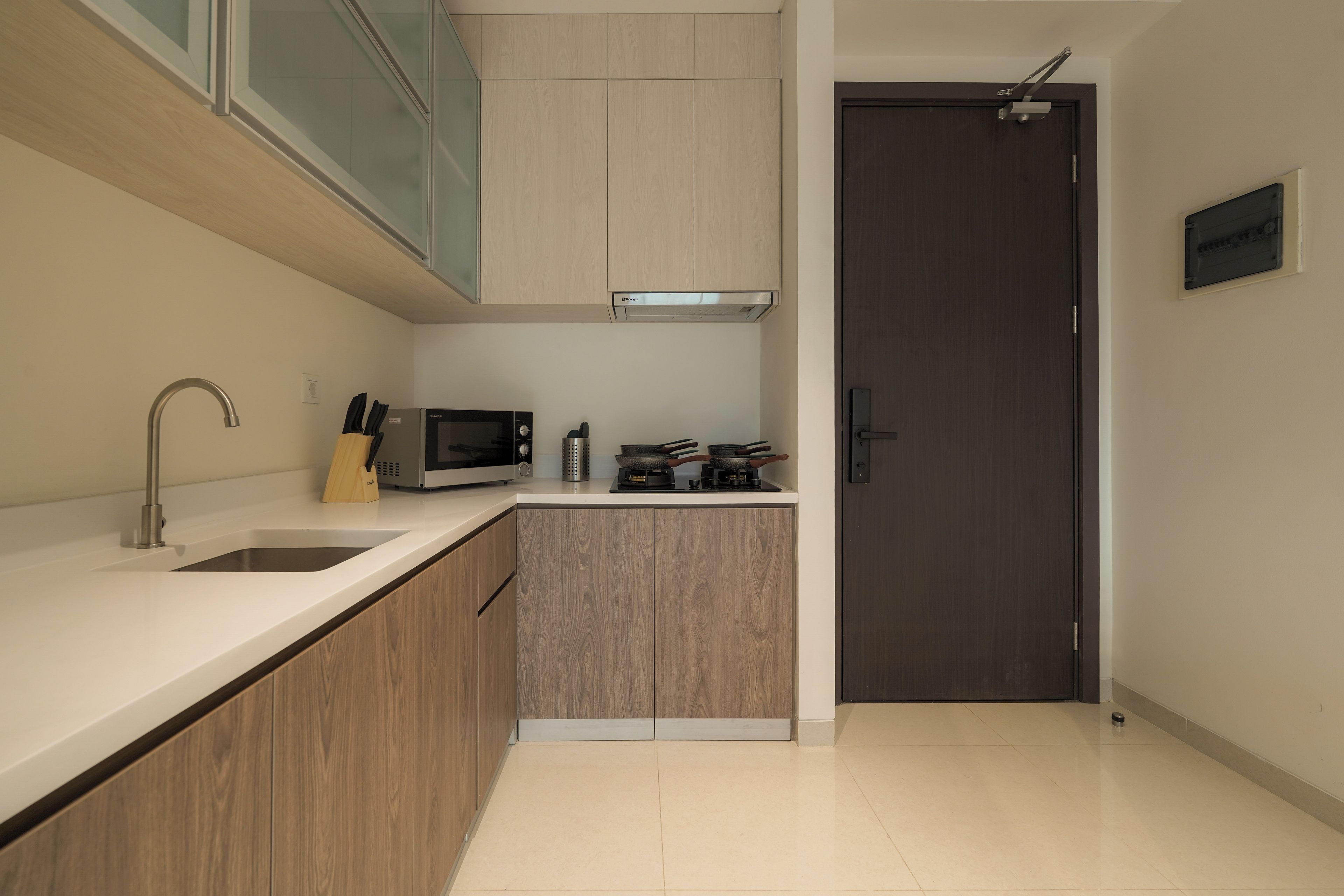 A modern kitchen with a stainless steel sink, a microwave, and a stove.