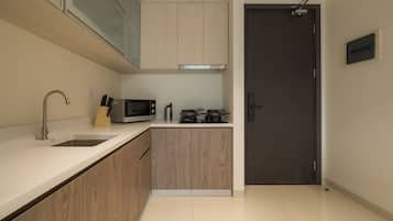 A modern kitchen with a stainless steel sink, a microwave, and a stove.