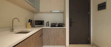 A modern kitchen with a stainless steel sink, a microwave, and a stove.