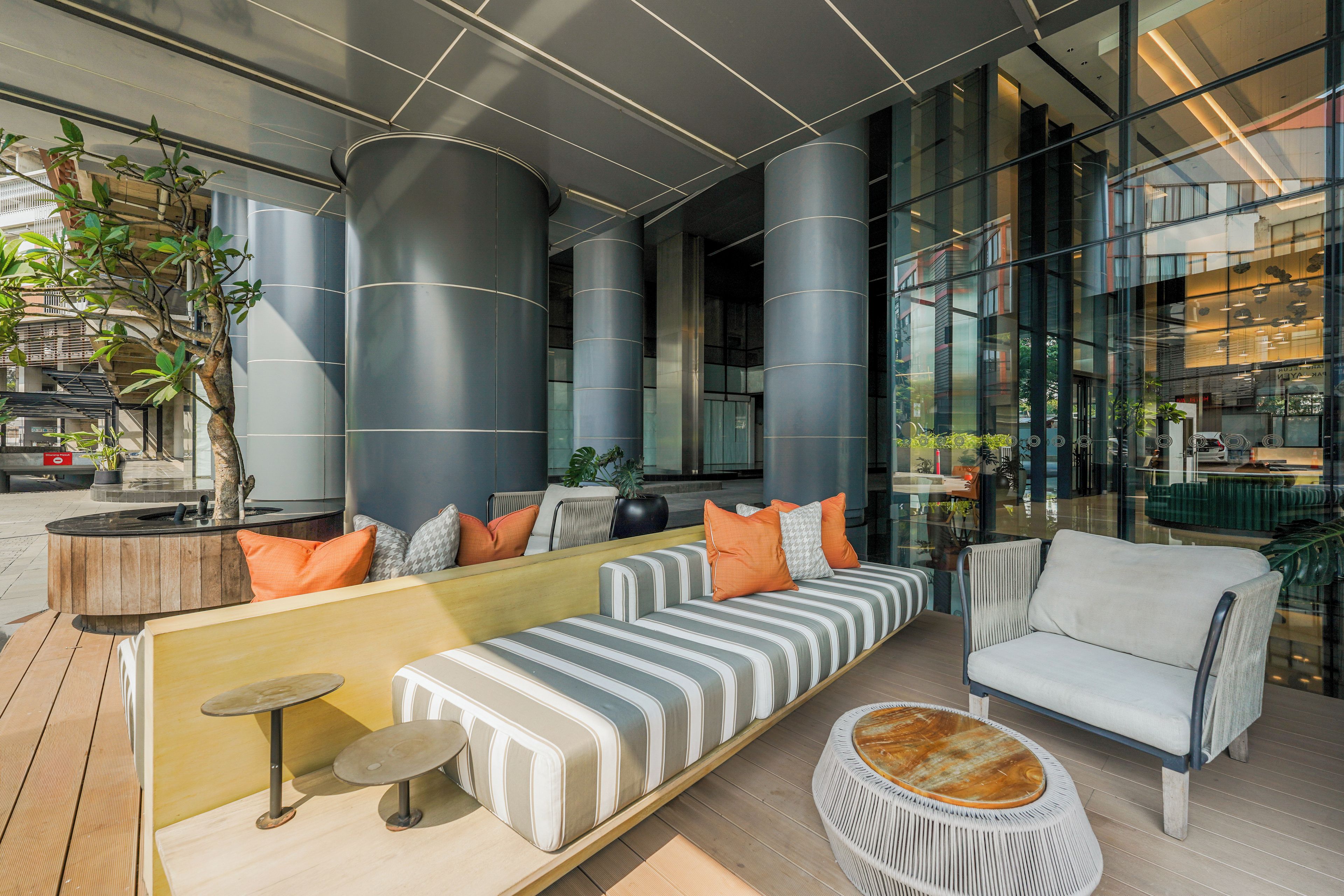 A modern lounge area with seating, a coffee table, and a potted plant.