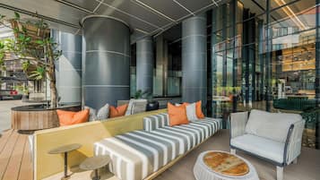 A modern lounge area with seating, a coffee table, and a potted plant.