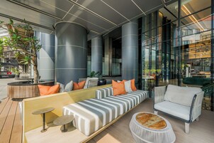 A modern lounge area with seating, a coffee table, and a potted plant.