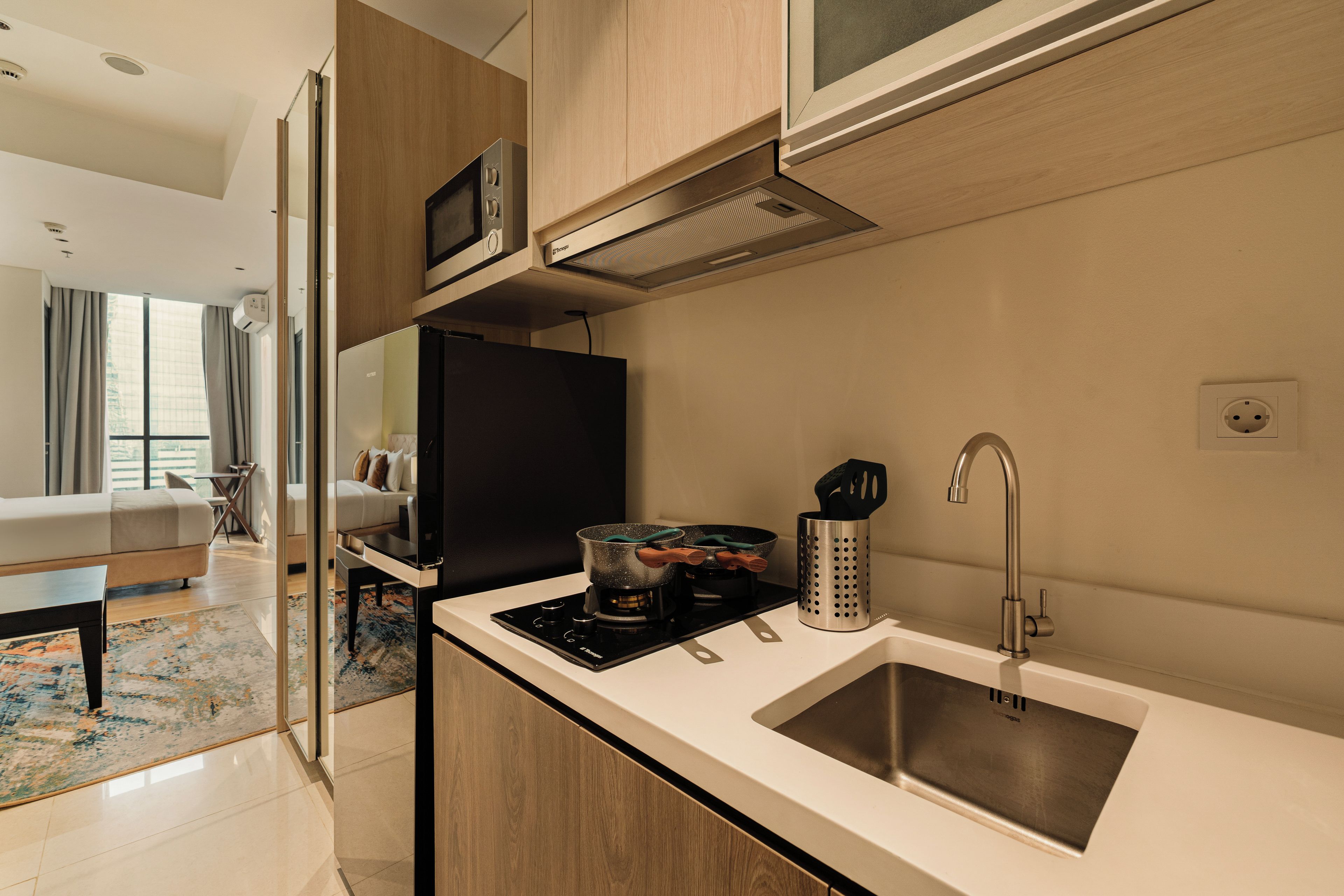 A modern kitchen with a built-in microwave, stove, and sink.