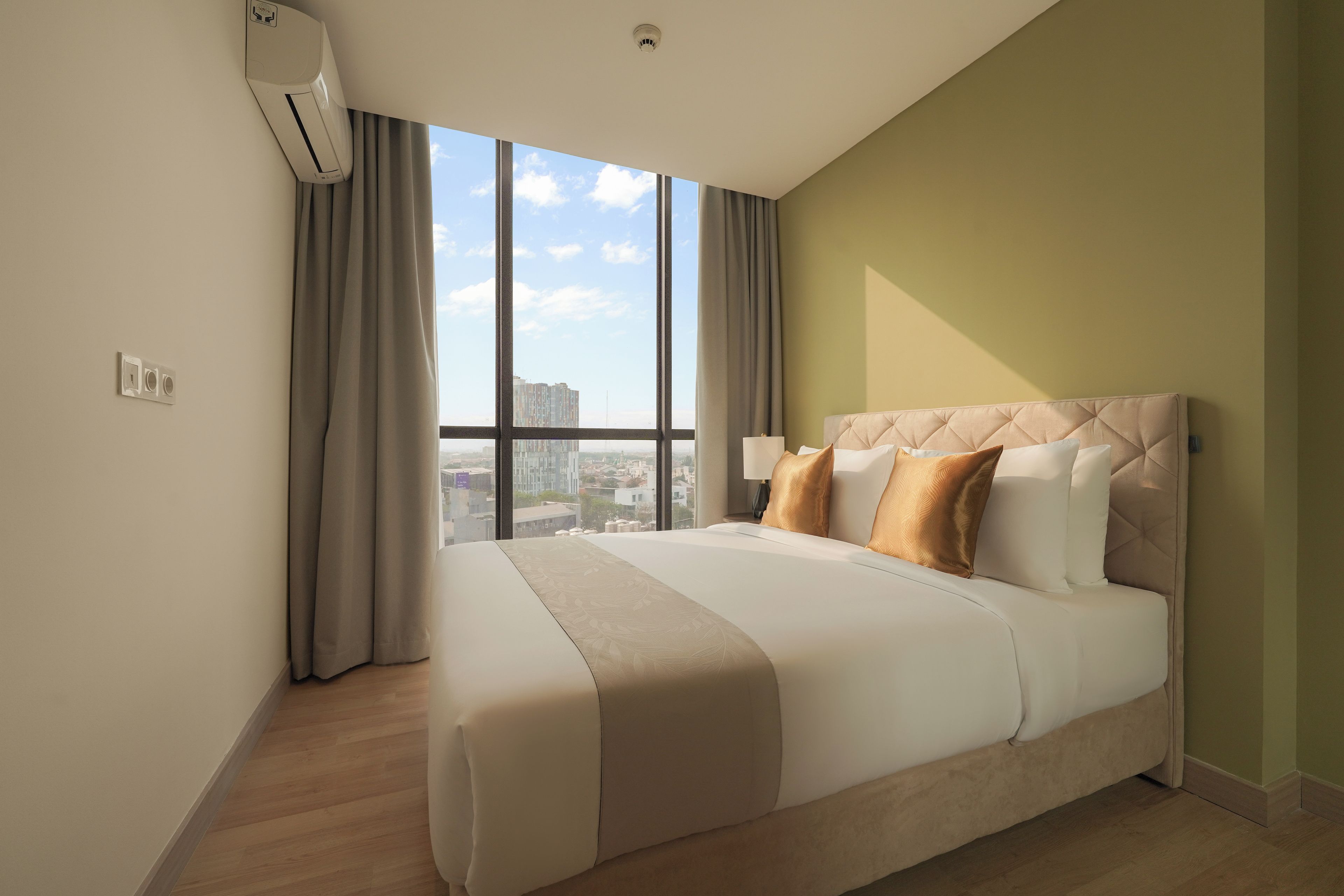 Quarto de hotel com uma cama grande, vista para a cidade e ar condicionado.