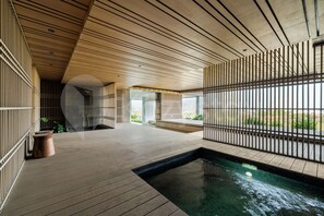A modern indoor pool area with a clear view of the surrounding landscape.