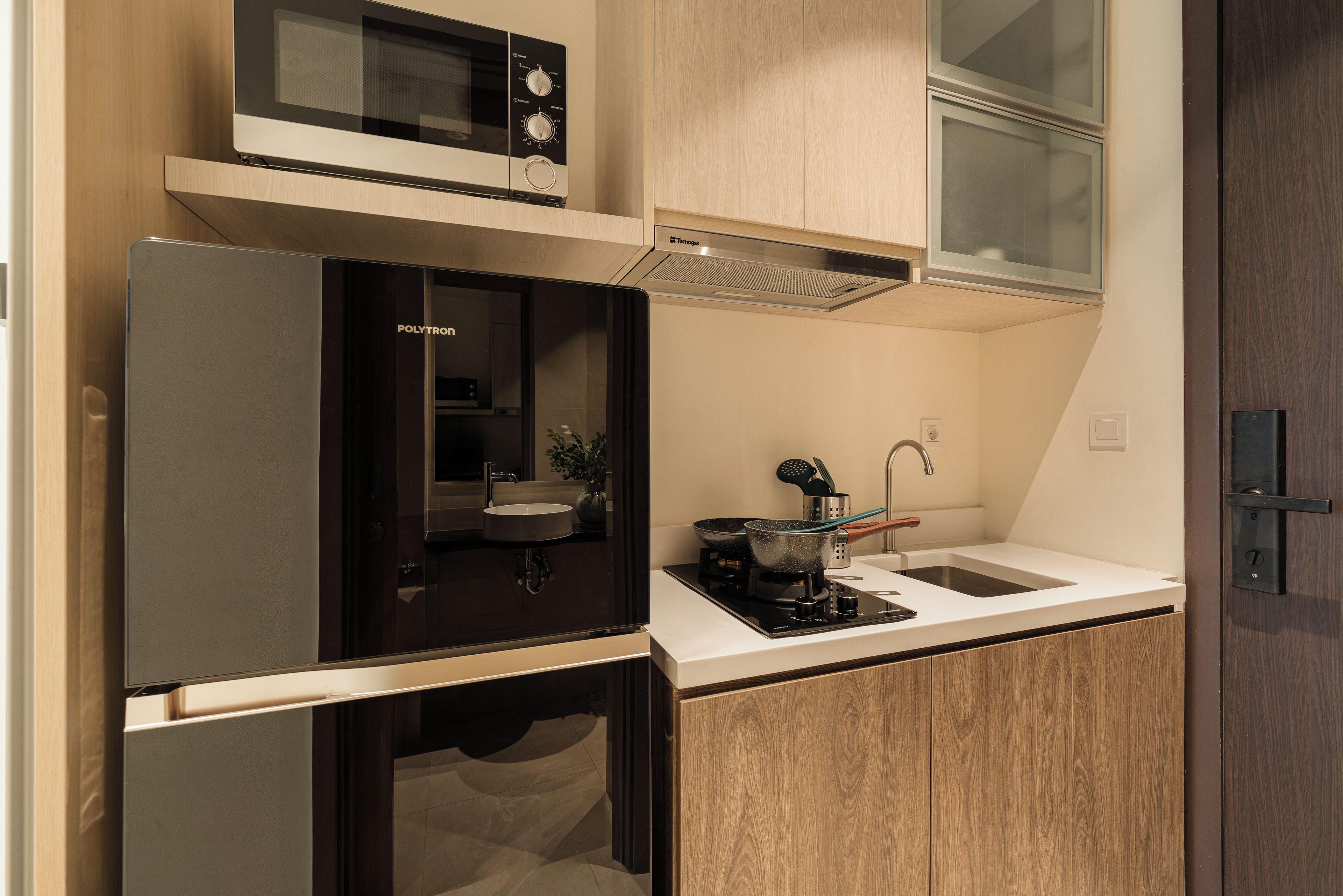A compact kitchen with a built-in microwave, a sink, and a stove.