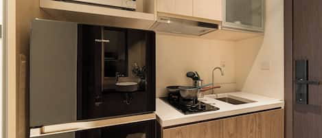 A compact kitchen with a built-in microwave, a sink, and a stove.