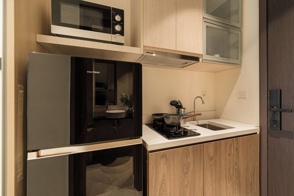 A compact kitchen with a built-in microwave, a sink, and a stove.