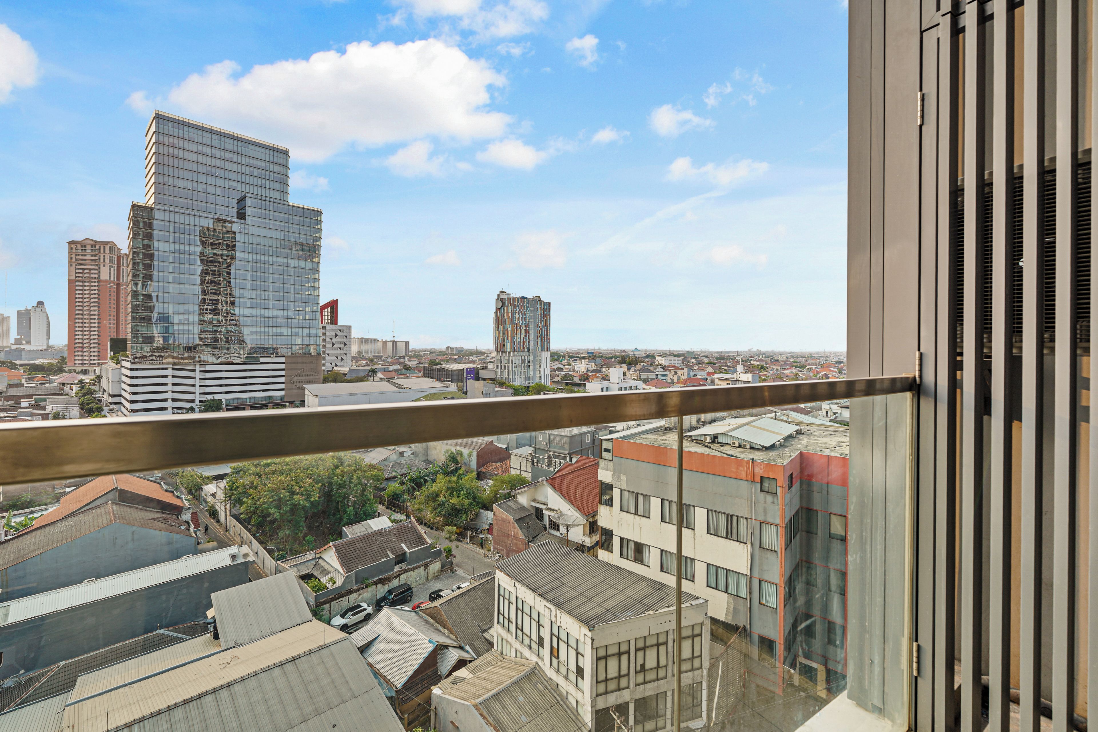 Een hoog gebouw met uitzicht op een stadsgezicht, inclusief diverse andere gebouwen en een heldere lucht.