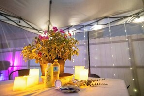 A table set up with a potted plant, candles, and bottles, likely for a dining or event setup. - BayNest Cozy South Miami Suite Long Stay Friendly (Cutler Bay)