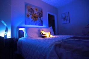 A bedroom with a bed, a nightstand, a lamp, and a painting on the wall. - BayNest Cozy South Miami Suite Long Stay Friendly (Cutler Bay)