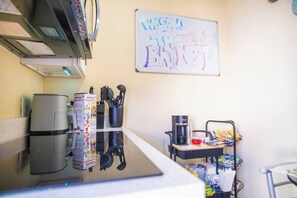 A kitchenette with a coffee maker, a water dispenser, and a whiteboard with a 'WELCOME TO BRANET' sign. - BayNest Cozy South Miami Suite Long Stay Friendly (Cutler Bay)