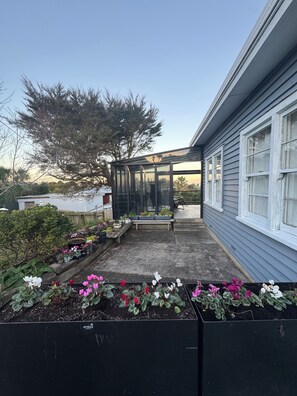 A residential property with a conservatory, potted plants, and a garden area. - Cosy beach retreat on Torbay. Enjoy a spacious room with entire house and garden (Torbay)