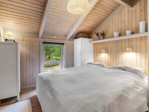 A bedroom with a bed, a wardrobe, a desk, and a window.