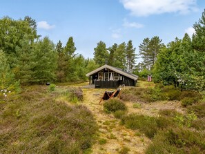 A cabin with a deck, surrounded by dense forest. - "Pia" - 685m from the sea by Interhome (Læsø)