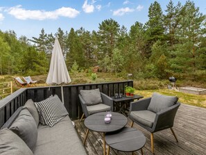 An outdoor deck with a sofa, chairs, a table, and an umbrella. - "Pia" - 685m from the sea by Interhome (Læsø)