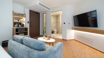 Una sala de estar moderna con un sofá, una mesa de centro y un televisor de pantalla plana montado en la pared.