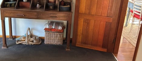 A room with a wooden cabinet, a patterned rug, and a wooden door.