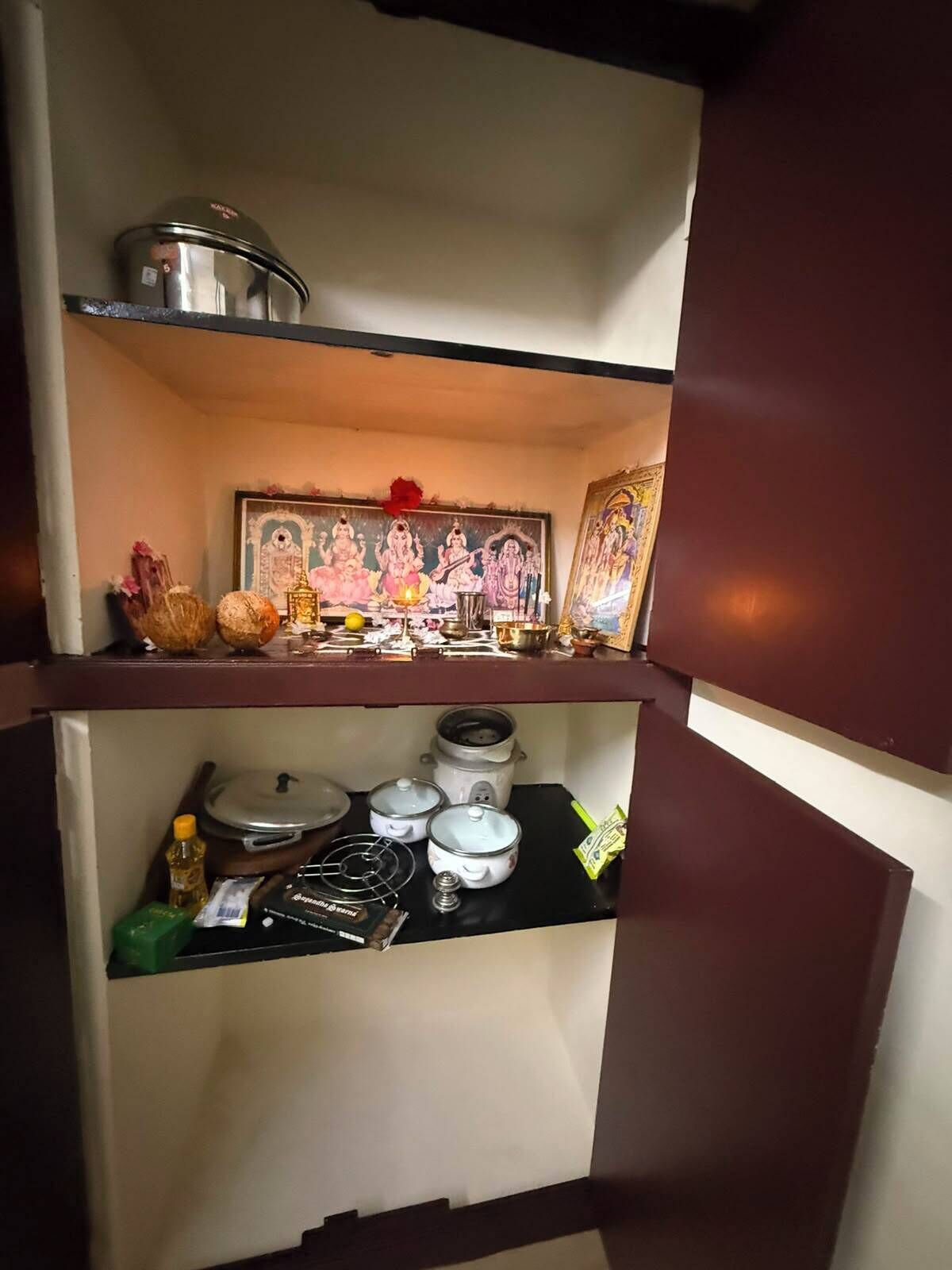 A shelf with a framed religious painting, a small statue, and a few decorative items.