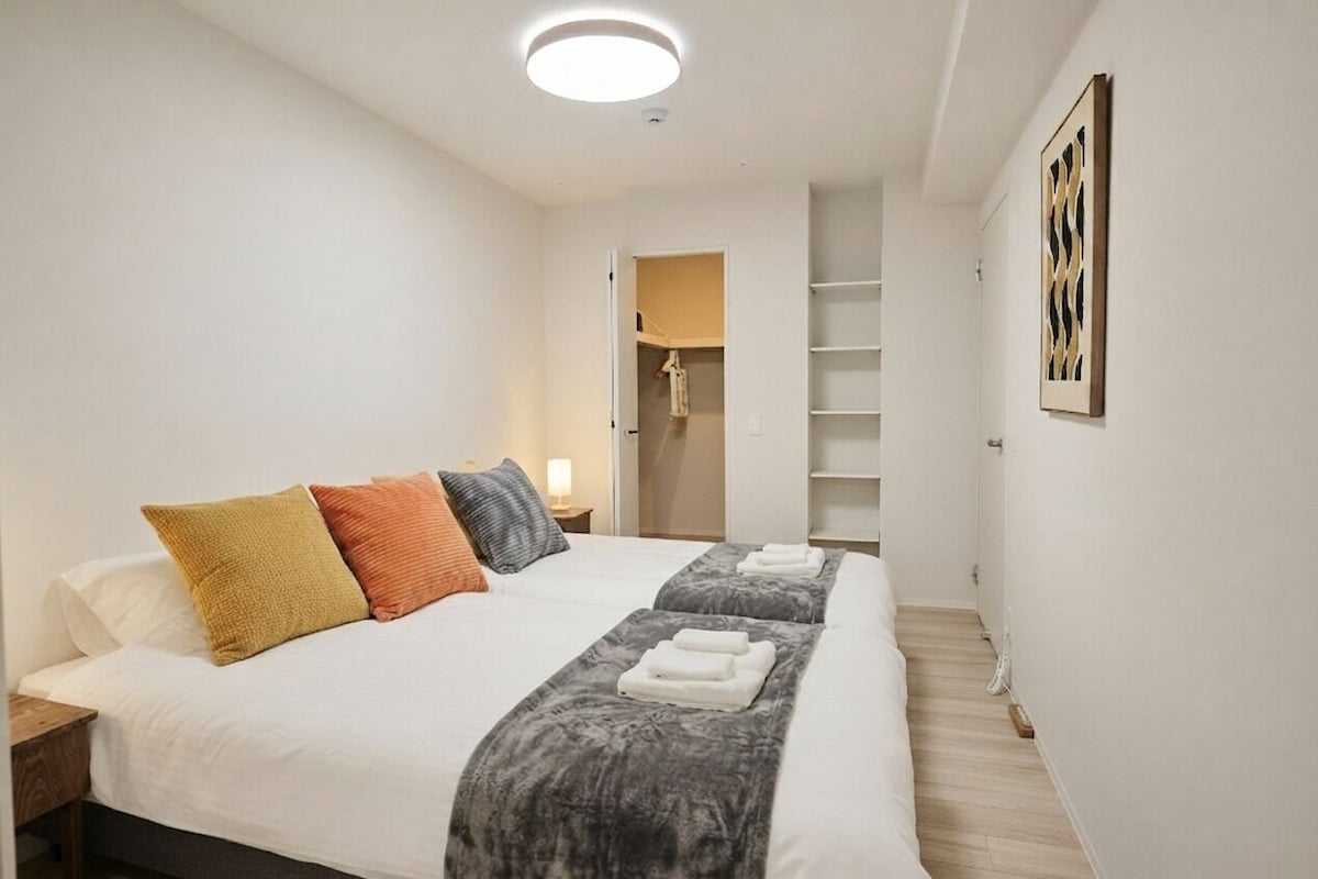 Ein Hotelzimmer mit einem Bett, einem Nachttisch, einem Schrank und einem gerahmten Kunstwerk an der Wand.