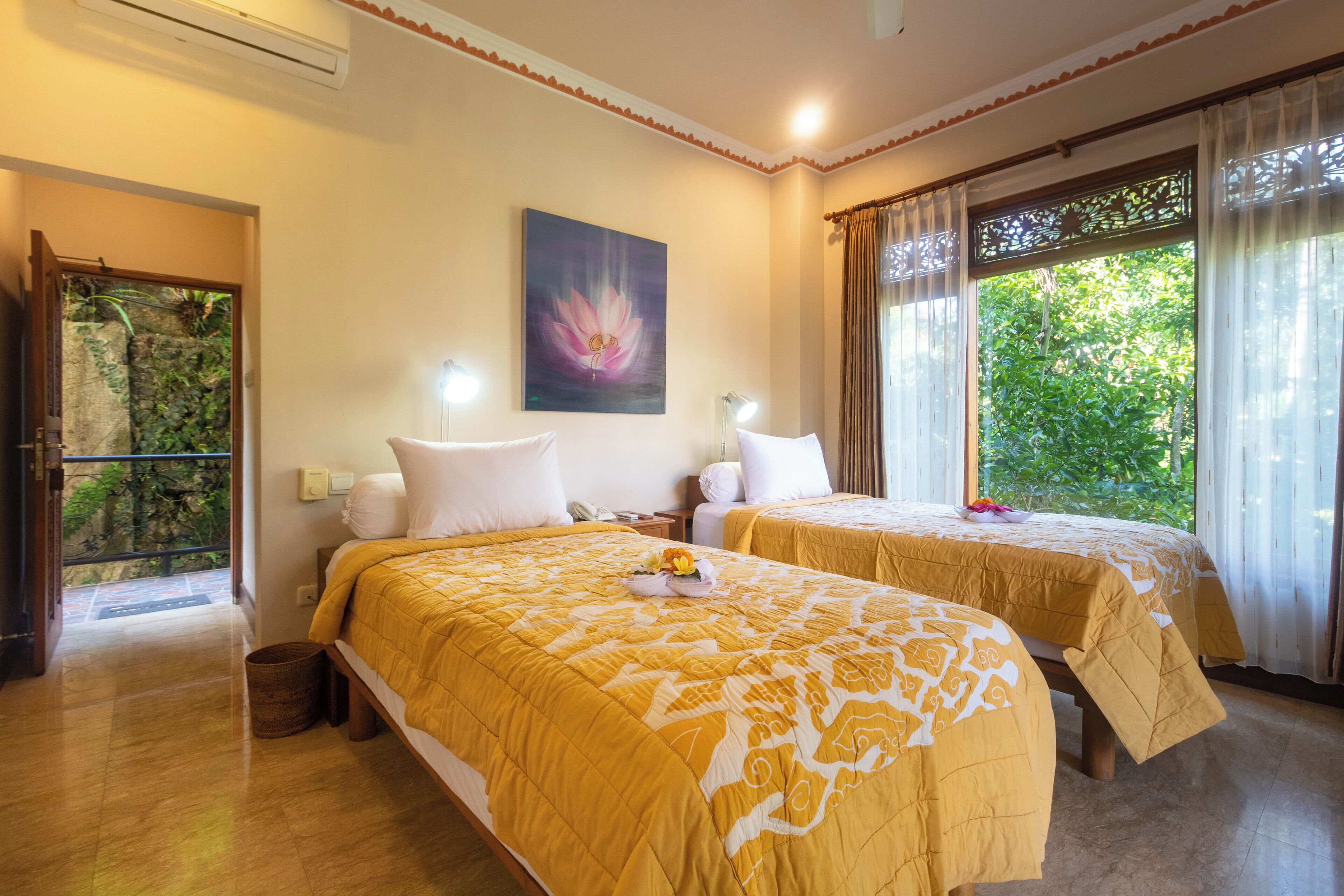 Habitación de hotel con dos camas, un cuadro en la pared y vistas a zonas verdes.