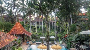 A resort with a swimming pool, lounge chairs, and umbrellas.