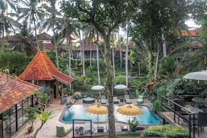 A resort with a swimming pool, lounge chairs, and umbrellas.