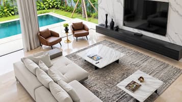 Un salon moderne doté d’un grand téléviseur, de sièges confortables et offrant une vue sur une piscine.