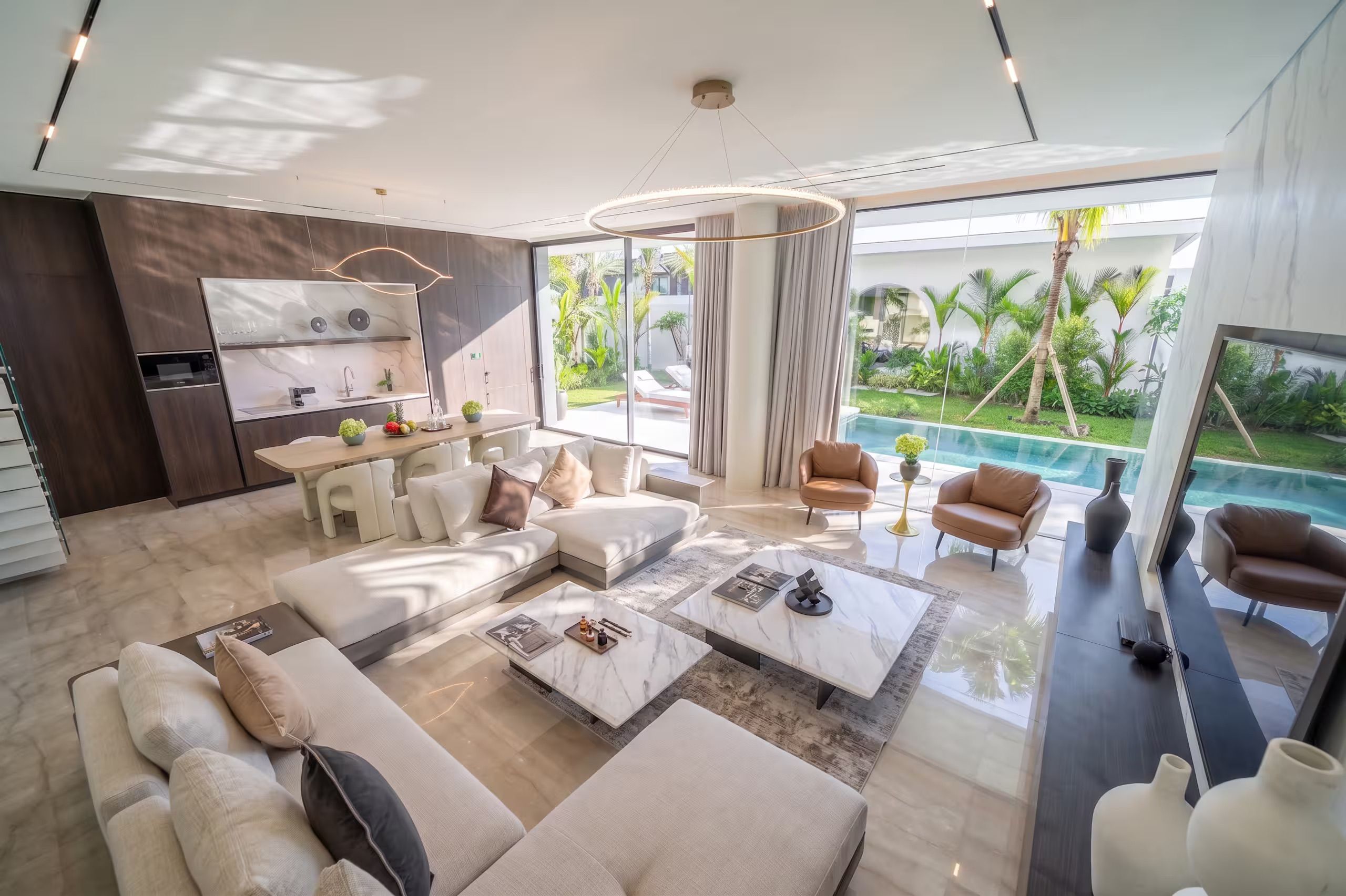 Un salon moderne avec vue sur la piscine, un coin repas et une cuisine.