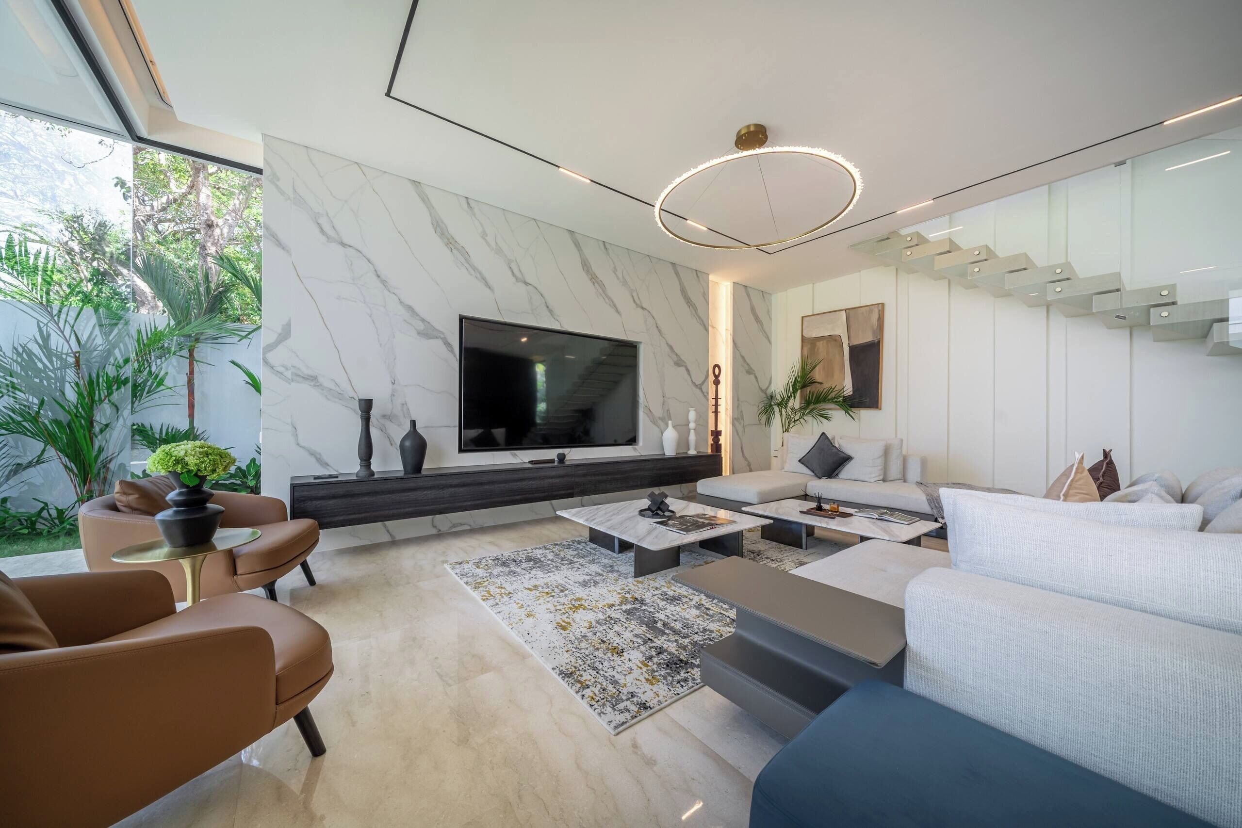 A modern living room with a flat-screen TV, a sofa, a coffee table, and a dining area.