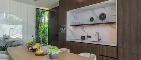 Una cocina moderna con salpicadero de mármol, armarios de madera y una isla integrada con asientos.