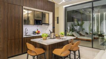 A modern kitchen with a central island, wooden cabinets, and a built-in microwave.