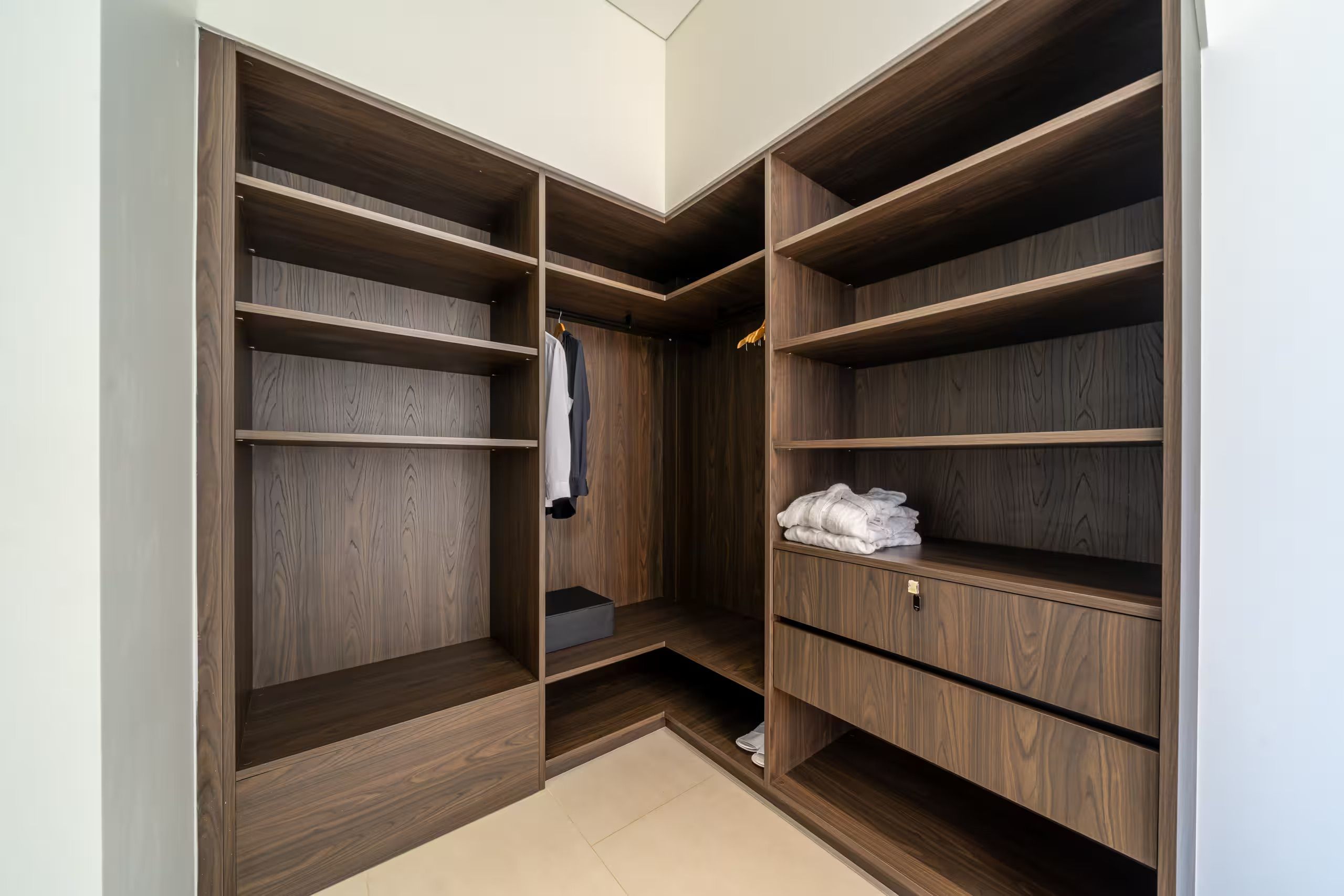 Ein begehbarer Kleiderschrank mit mehreren Holzböden und einer Kleiderstange.