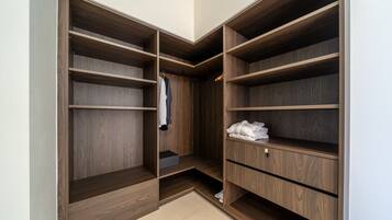 Ein begehbarer Kleiderschrank mit mehreren Holzböden und einer Kleiderstange.