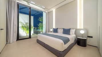 Een moderne slaapkamer met een groot bed, een nachtkastje, een lamp en uitzicht op groen via een glazen deur.