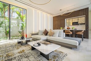 A modern living room with a sectional sofa, a coffee table, and a dining area with chairs.