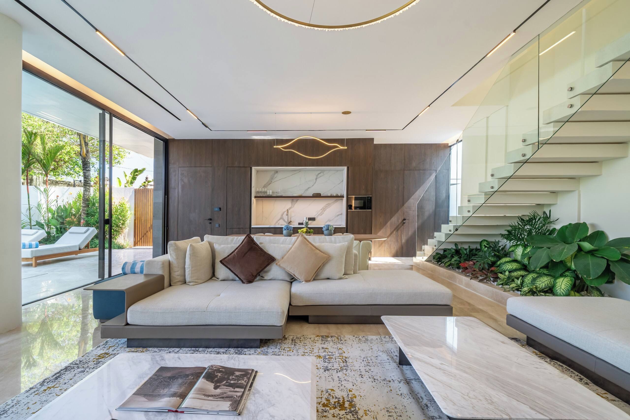 Un salon moderne avec un canapé d’angle, une table basse et un escalier.