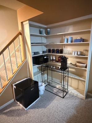 A compact kitchen with built-in shelves, a microwave, and a small table.
