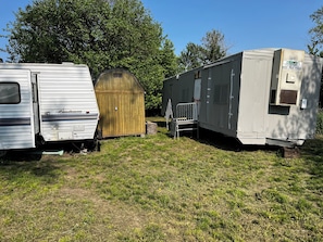 A row of RVs and a wooden shed in a grassy area. - Missouri River Cabin near Northwest Missouri, Southeast Nebraska, Southwest Iowa (Hamburg)