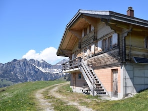 A wooden mountain cabin with a balcony and a staircase leading to the entrance. - Alphütte Weissenberg Hütte, WC, 2 Schlafräume 5-Bettwohnung by Interhome (Lenk)