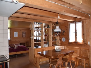 A wooden interior with a dining area, kitchen, and a bed. - Alphütte Weissenberg Hütte, WC, 2 Schlafräume 5-Bettwohnung by Interhome (Lenk)