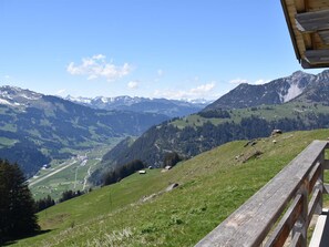 A mountainous landscape with a wooden fence, a road, and scattered buildings. - Alphütte Weissenberg Hütte, WC, 2 Schlafräume 5-Bettwohnung by Interhome (Lenk)